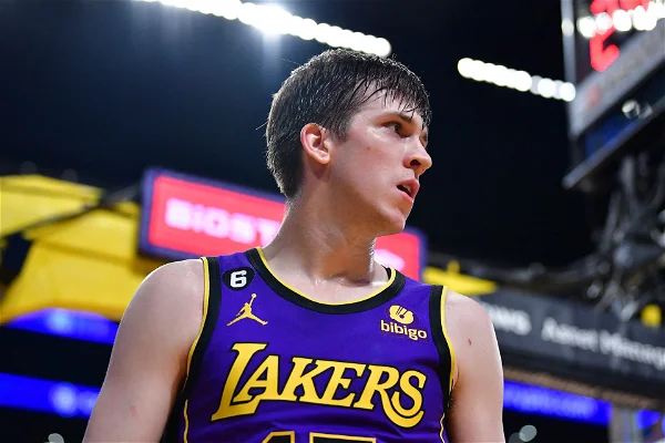 L'image montre un jeune joueur de basket dans l'uniforme mauve des Lakers